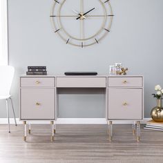 a desk with two drawers and a clock on the wall above it in a living room