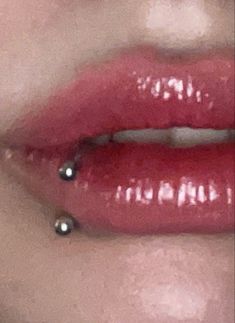 a woman's lips with piercings on them