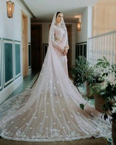 a woman in a wedding dress is standing on the floor with her veil draped over her head