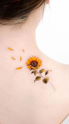 a sunflower tattoo on the back of a woman's neck, with yellow petals