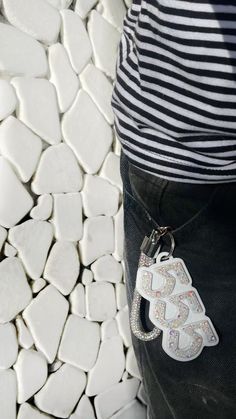 a person standing in front of a pile of white rocks with an elephant keychain on it