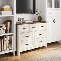 a living room with white bookcases and a flat screen tv