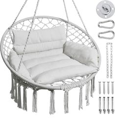 a white hanging chair with pillows and chains on it's side, next to screws