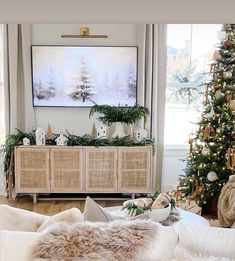 the living room is decorated for christmas with white and green decorations on the tree, wicker furniture, and large windows