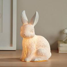 a white rabbit lamp sitting on top of a wooden table