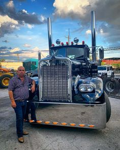 a man standing next to a large semi truck