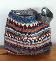 a crocheted bag sitting on top of a wooden table