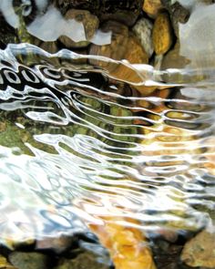 the reflection of rocks and water on top of each other