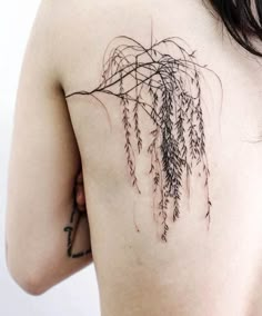 the back of a woman's shoulder with tattoos on it