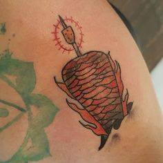 a tattoo on the back of a woman's arm with a piece of meat in it