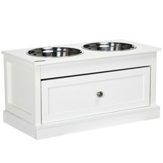 two white bowls on top of each other in front of a white cabinet with drawers