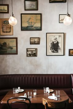 a table with place settings and pictures on the wall in a restuarant area