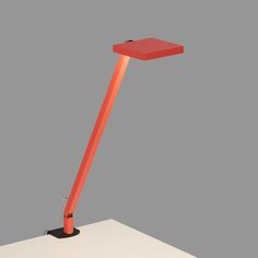 an orange floor lamp sitting on top of a white table