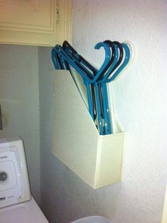 there is a bunch of blue scissors in the holder on the wall next to the washer