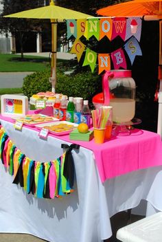 a table that has some food and drinks on it with an umbrella in the background