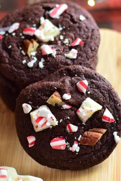 two chocolate cookies with candy canes and marshmallows