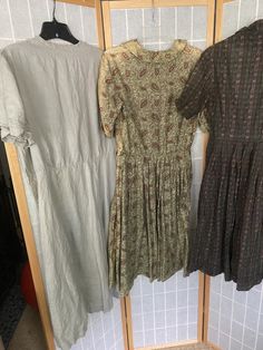 "Lot of 4 1950's dresses 1. Light blue cotton dress, has underarm discoloration. Bust 39\" waist 27\" hips free 2. Green paisley, major sun fading, see photos. 42\" bust 28\" waist hips free 3. Grey linen dress, small stains throughout. 50\" bust 40\" waist 48\" hips 4. Green and brown cotton paisley striped dress. Missing all but two buttons. Bust 36\" waist 25\" hips free. All being sold as is, will need repairs" A-line Dress With Vintage Print For Vintage Fashion, 1950s Vintage Pattern Dress For Vintage Fashion, Vintage Cotton Dresses With Vintage Pattern, Lined Short Sleeve Dress For Vintage Events, Cotton Vintage Dress With Vintage Pattern, Fitted Casual Dress For Vintage Fashion, 1950s Short Sleeve Dress For Vintage Fashion, 1950s Style Short Sleeve Vintage Dress, 1950s Style Vintage Fashion Dress With Short Sleeves