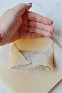 a person holding their hand over some uncooked ravioli