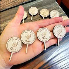 a person is holding several wooden pins in their hand with the words great cheese on them