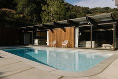 an empty swimming pool with chairs around it