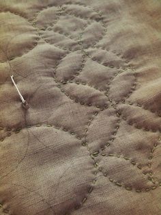 a close up of a piece of cloth with stitching on it and a needle in the middle