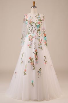 a white wedding dress with flowers on the bouncy skirt and long sleeved sleeves