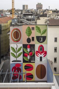 an apartment building with colorful paintings on the side of it's wall and balcony