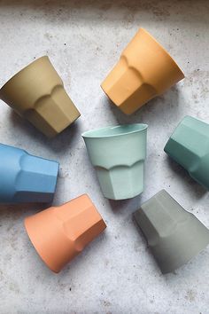 six different colored cups sitting on top of a counter