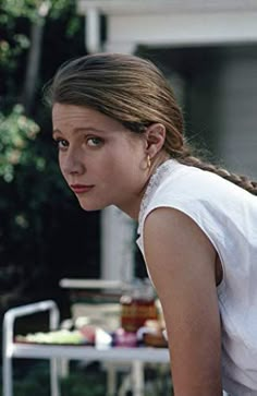 a woman in white shirt holding a tennis racquet