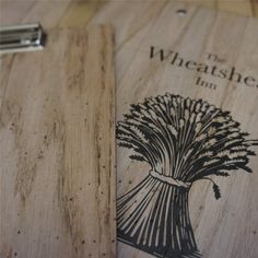 a wooden cutting board with the words wheathead inn on it and a clipboard attached to it