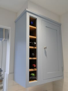 a kitchen cabinet with wine bottles in it