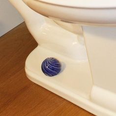 a white toilet sitting on top of a wooden floor