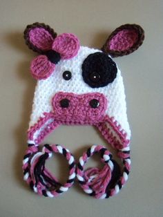 a crocheted cow hat with ear flaps