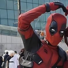 a man in a deadpool costume poses for the camera with his hands behind his head