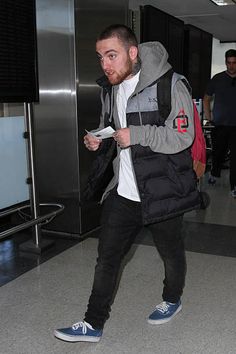 a man walking through an airport carrying a bag