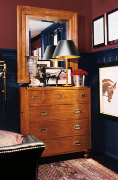 a dresser with two lamps and pictures on it