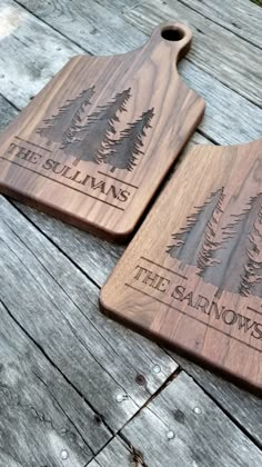 two wooden cutting boards with trees engraved on them