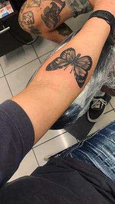 a person with a butterfly tattoo on their arm