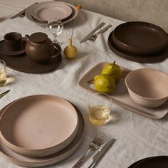 the table is set with plates, bowls and utensils