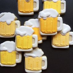 beer mugs are decorated on cookies with frosty icing and yellow highlights, as well as white trim