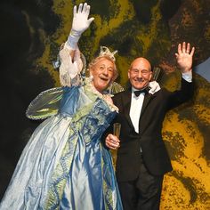 an older man and woman dressed in fancy clothing wave at the camera as they pose for a photo