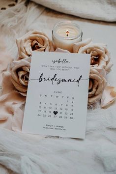 a candle and some flowers on a white blanket with a card that says bridesmal