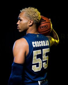 a man holding a basketball on his shoulder