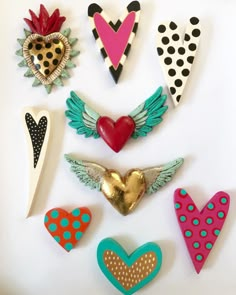 several heart shaped brooches are arranged on a white surface with polka dots and hearts