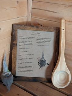 a wooden spoon sitting on top of a table next to a framed book with a poem written in it