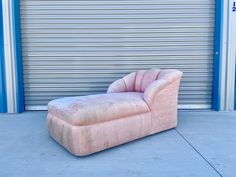 a pink chair sitting in front of a garage door next to a closed roller door