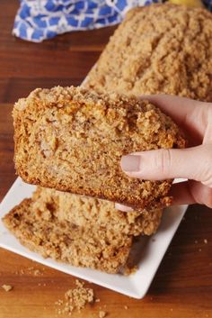 two pieces of bread are being held by someone's hand on a white plate