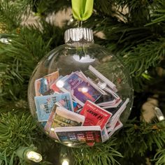 a glass ornament filled with books on top of a christmas tree