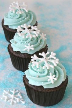 three cupcakes decorated with frosting and snowflakes