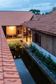 an outside view of a house with water and plants